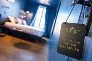 a sign on a wall in a room with a couch at Boutique Hotel Nice Côte d'azur in Nice