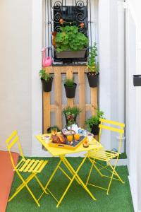 a yellow table and chairs on a patio with plants at Boutique Hotel Nice Côte d'azur in Nice