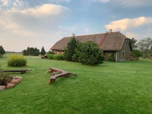 a house with a yard with benches in the grass at Muha Beach Holiday Home in Riksu