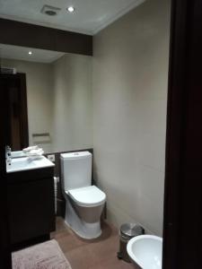 a bathroom with a white toilet and a sink at Apartment Troia Garden in Troia