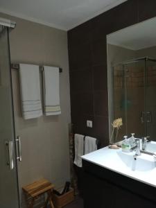 uma casa de banho com um lavatório e um espelho em Apartment Troia Garden em Tróia