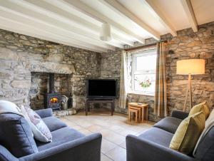a living room with stone walls and a stone fireplace at Fron Fawr in Nefyn
