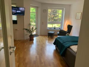 1 dormitorio con 1 cama, 1 silla y TV en Wohlfühl-Wohnung in gehobener Gegend en Magdeburgo