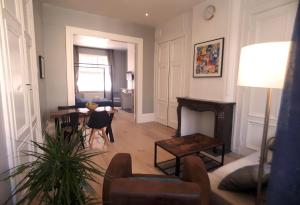 a living room with a table and a fireplace at Le Jardin de Ligny in Saint-Omer