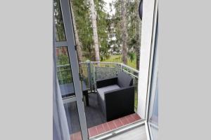 - un balcon avec une chaise sur la terrasse couverte dans l'établissement Ferienwohnung am Kurwald in Bad Lippspringe, à Bad Lippspringe