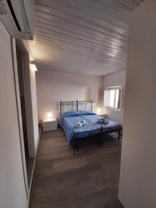 um quarto com uma cama com um edredão azul em Alba Del Borgo em Recanati