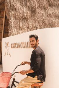 a man standing in front of a wall with a surfboard at Encantada Tulum in Tulum