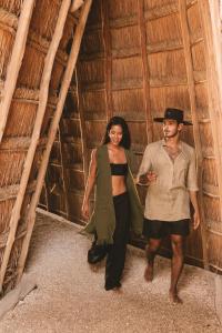 Ein Mann und eine Frau stehen in einer Hütte in der Unterkunft Encantada Tulum in Tulum