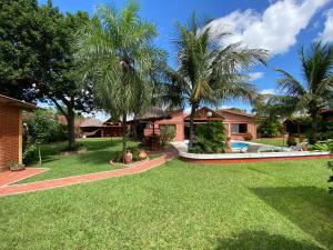 un patio con palmeras y una casa en Casa por Temporadas, en Santa Cruz de la Sierra