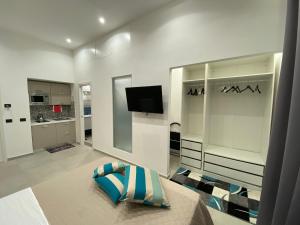 uma sala de estar com uma televisão e um sofá em Room25mq em Cercola