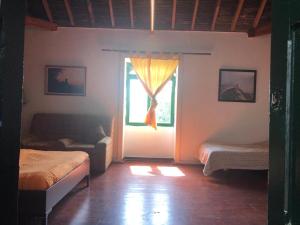 a room with two beds and a window at Rural Home, Finca Ecocielo in Vega de San Mateo