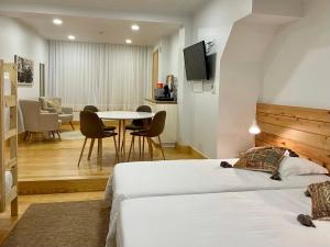 a hotel room with two beds and a table at PDL Green House in Ponta Delgada