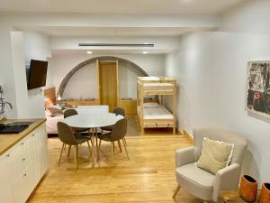 a living room with a table and chairs and a bedroom at PDL Green House in Ponta Delgada