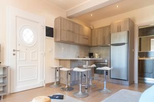 a kitchen with wooden cabinets and bar stools at Villa Eleftheria in Vitalades +24 photos