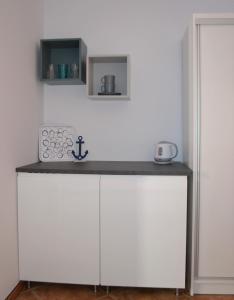 a white cabinet with a sink in a room at Międzywodami Jastarnia in Jastarnia