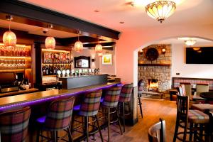 a bar in a restaurant with a fireplace at The Leitrim Inn and Blueway Lodge in Leitrim