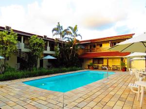 a swimming pool in front of a building at Pousada Berro D'Água in Cananéia