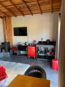 a living room with a table and a tv at Chalé dos Pássaros in Gramado