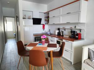 a kitchen with a table and chairs in a room at Sea Sound Haraki apartment in Haraki