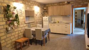 uma cozinha com mesa e cadeiras num quarto em Bakina kuća em Golubac