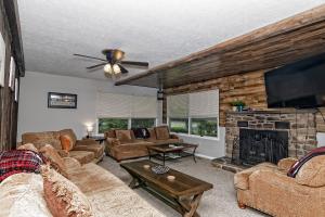 una sala de estar con sofás y una chimenea de piedra. en Camelback Rd Rancher- On ONE ACRE & near attractions en Tannersville