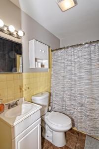 ein Badezimmer mit einem WC, einem Waschbecken und einem Duschvorhang in der Unterkunft Camelback Rd Rancher- On ONE ACRE & near attractions in Tannersville