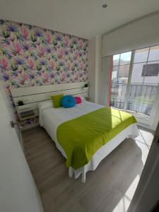1 dormitorio con 1 cama con manta amarilla en Ático Chill Out la Biznaga, en Málaga