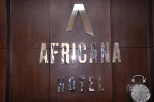 letrero de aazon en una puerta de madera con reloj en Africana Hotel, en Dubái