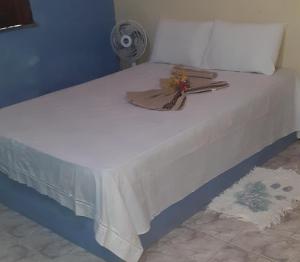 a white bed with a fan on top of it at casa sarnambi in Atins