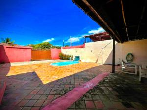 une cour arrière avec une piscine et un bâtiment dans l'établissement Casa de praia em Cotovelo, à Parnamirim