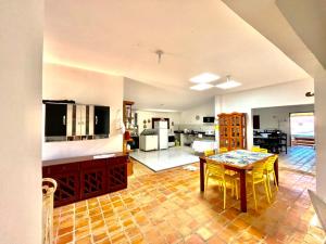 a living room with a table and a kitchen at Casa de praia em Cotovelo in Parnamirim