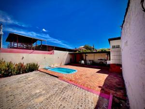 une cour arrière avec une piscine et un bâtiment dans l'établissement Casa de praia em Cotovelo, à Parnamirim