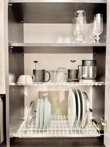 a kitchen with plates and utensils on a shelf at Апартаменты в Аркадии - Arcadia Sky Apartments in Odesa