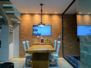 a dining room with a wooden table and chairs at Vila dos Milagres Casa de Charme in São Miguel dos Milagres
