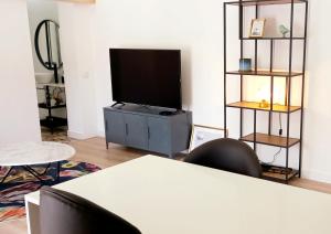 ein Wohnzimmer mit einem Flachbildfernseher auf einem Fernsehtisch in der Unterkunft Luisa's Loft in Setúbal
