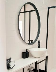 a bathroom with a white sink and a mirror at Luisa's Loft in Setúbal