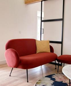 uma sala de estar com uma cadeira vermelha e uma mesa em Luisa's Loft em Setúbal