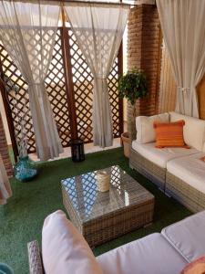 ein Wohnzimmer mit weißen Sofas und einem Tisch in der Unterkunft Ático Chill Out la Biznaga in Málaga