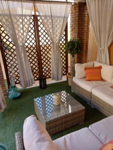 a living room with white couches and a table at Ático Chill Out la Biznaga in Málaga