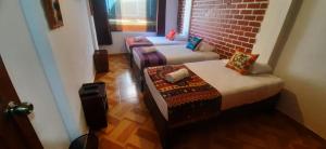 En eller flere senger på et rom på Quipu Hostal