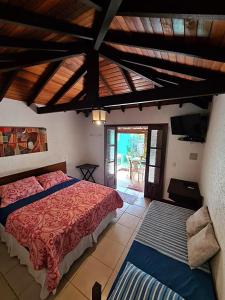 a bedroom with a bed and a view of a patio at Casinha Astral - Praia da Ferrugem in Garopaba