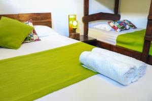 2 Betten in einem Zimmer mit Grün und Weiß in der Unterkunft Eco del Mar in La Libertad