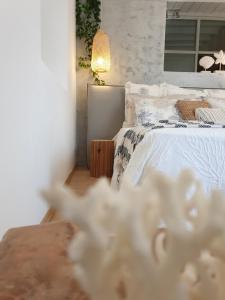 a bedroom with a white bed and a mirror at Aretousa Deluxe Downtown Apartment in Skala