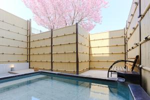 a swimming pool with a fence and a tree at Hotel Route Tsukuba in Tsukuba