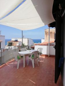 einen weißen Tisch und Stühle auf einem Balkon mit Meerblick in der Unterkunft By the Sea Apartment #4 in Terrasini