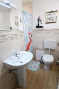 ein Badezimmer mit einem weißen Waschbecken und einem WC in der Unterkunft By the Sea Apartment #4 in Terrasini