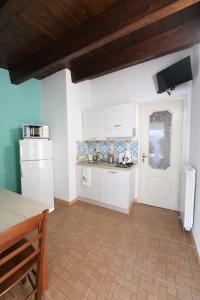 eine Küche mit weißen Geräten und einer Holzdecke in der Unterkunft By the Sea Apartment #4 in Terrasini