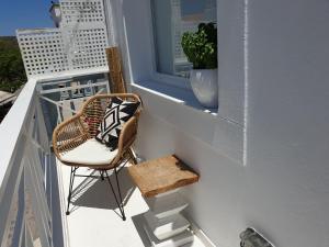 a chair sitting on a balcony with a window at Aretousa Deluxe Downtown Apartment in Skala