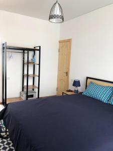 1 dormitorio con 1 cama grande con manta azul en Family Guest House en Cholpon-Ata