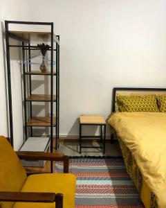 ein Schlafzimmer mit einem Bett, einem Stuhl und einem Tisch in der Unterkunft Family Guest House in Tscholponata